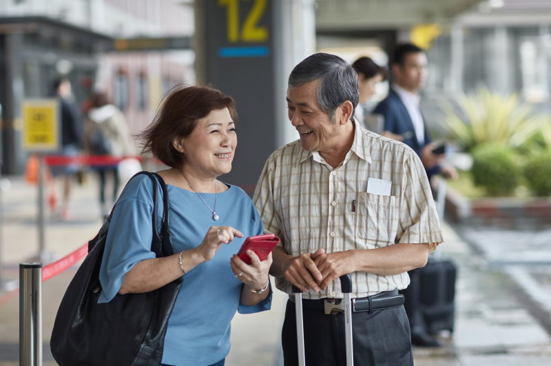 Two Seniors at Airport Smiling